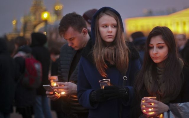 Young people hold candles as they gather to honor the memory of the victims of subway bombing on Marsovo Polye in St. Petersburg, Russia, Wednesday, April 5, 2017. (AP/Yevgeny Kurskov)