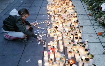 A girl lights candles in front of the department store Ahlens in Stockholm, Sweden, Sunday, April 9, 2017. (AP Photo/Markus Schreiber)
