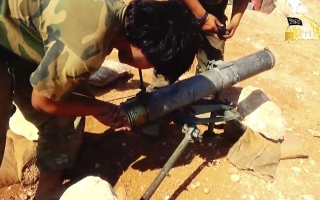 This frame grab from video provided in August 6, 2016, by Turkistan Islamic Party, a militant website outlet that is consistent with independent AP reporting, shows a fighter from the Turkistan Islamic Party prepares to fire a missile, during a battle against the Syrian government forces, in Aleppo, Syria. ( Militant Website Turkistan Islamic Party, via AP)