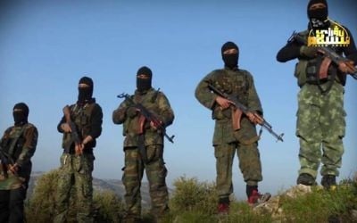 In this undated photo released by Turkistan Islamic Party, a militant website, which has been verified and is consistent with other AP reporting, shows fighters from the Turkistan Islamic Party holds their weapons, at unknown place in Syria.   ( Militant Website Turkistan Islamic Party via AP)