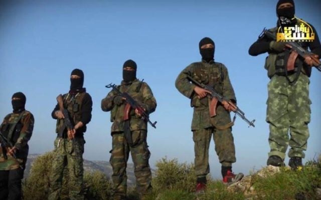 In this undated photo released by Turkistan Islamic Party, a militant website, which has been verified and is consistent with other AP reporting, shows fighters from the Turkistan Islamic Party holds their weapons, at unknown place in Syria. ( Militant Website Turkistan Islamic Party via AP) In this undated photo released by Turkistan Islamic Party, a militant website, which has been verified and is consistent with other AP reporting, shows fighters from the Turkistan Islamic Party holds their weapons, at unknown place in Syria. ( Militant Website Turkistan Islamic Party via AP)