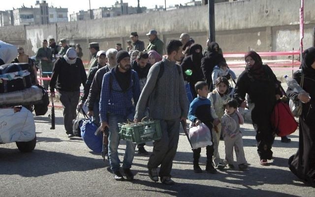 In this photo released by the Syrian official news agency SANA, Syrian opposition fighters head to a bus with their families as they leave the last rebel-held neighborhood of al-Waer, in Homs province, Syria, Monday, April 24, 2017. (SANA via AP) In this photo released by the Syrian official news agency SANA, Syrian opposition fighters head to a bus with their families as they leave the last rebel-held neighborhood of al-Waer, in Homs province, Syria, Monday, April 24, 2017. (SANA via AP)