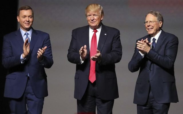 US President Donald Trump stands with National Rifle Association Executive Vice President Wayne LaPierre, R, and Chris W. Cox, executive director of the National Rifle Association Institute for Legislative Action as he arrives for the National Rifle Association Leadership Forum, Friday, April 28, 2017, in Atlanta. (Curtis Compton/Atlanta Journal-Constitution via AP)