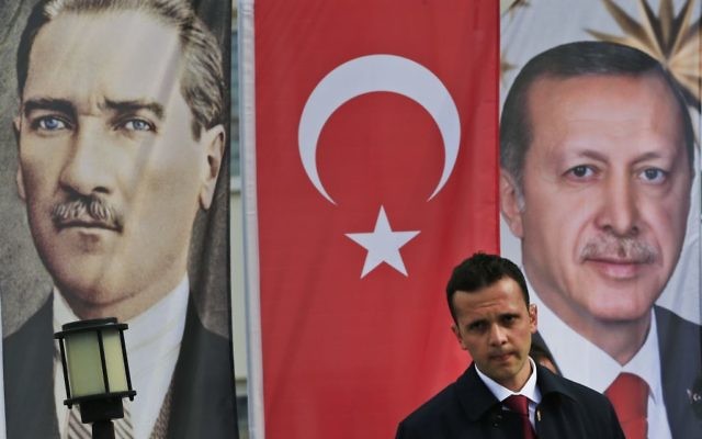 In this Monday, April 3, 2017 photo, backdropped by banners showing modern Turkey's founder Mustafa Kemal Ataturk, left and Turkey's current President Recep Tayyip Erdogan, right, a member of security for Erdogan stands guard following his speech at a rally in his hometown Black Sea city of Rize, Turkey. Turkey is heading toward a historic referendum on Sunday April 16, 2017, with voters deciding whether to approve constitutional amendments that would replace the parliamentary system by a presidential one, scrapping the office of the prime minister and handing over its powers to Erdogan. (AP Photo/Lefteris Pitarakis)