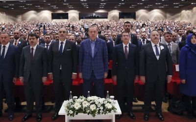 Turkey's President Recep Tayyip Erdogan, center, stands as he listens to the national anthem, prior of delivering a speech at a conference in Istanbul, Saturday, April 29, 2017 (Press Presidency Press Service via AP, Pool)