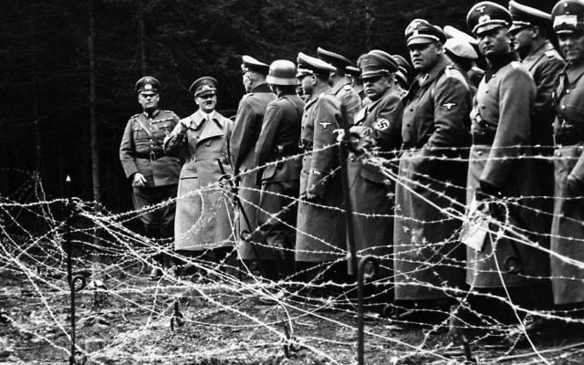 In this Oct. 6, 1938, file photo, Adolf Hitler, second from left, stands in front of the barbed wire fortifications at Kreuzbuche, Germany after German troops advanced and occupied the second zone of Sudetenland.  (AP, File)
