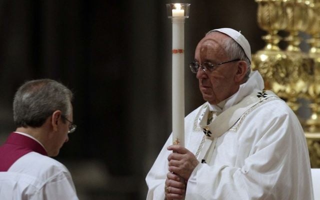 Pope Francis holds a candle as he presides over a solemn Easter vigil ceremony in St. Peter's Basilica at the Vatican, Saturday, April 15, 2017. (AP Photo/Andrew Medichini)