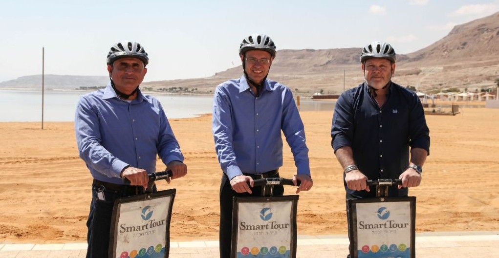 From left to right, Shimon Daniel, the CEO of the Dead Sea Preservation Government Company Ltd, which oversaw the development of the new promenade and infrastructure, Tourism Minister Yariv Levin, and Tamar Regional Council Mayor Dov Litvinoff ride segways on the new promenade in Ein Boqek on April 3, 2017. (courtesy Mickey Lengental)