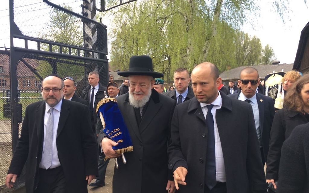 Rabbi Yisrael Meir Lau (c), Education Minister Naftali Bennett (r) join participants in the March of the Living in Auschwitz concentration camp, April 24, 2017 (Courtesy)
