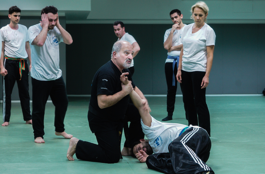 Avi Attlan, kneeling, teaching Krav Maga to students in Saint Mande, March 23, 2017. (Cnaan Liphshiz/JTA) Avi Attlan, kneeling, teaching Krav Maga to students in Saint Mande, March 23, 2017. (Cnaan Liphshiz/JTA)