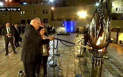 President Reuven Rivlin lights the memorial flame on together with the widow of a fallen IDF soldier Hagi Ben Ari at the official Memorial Day ceremony at the Western Wall in Jerusalem on April 30, 2017. (screen capture: Channel 2)
