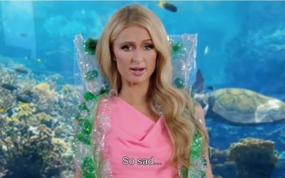 Paris Hilton sports a cape made of plastic bottles that allegedly came from the stomachs of sea turtles in a mock ad released by SodaStream on March 29, 2017. (Screen capture/YouTube) Paris Hilton sports a cape made of plastic bottles that allegedly came from the stomachs of sea turtles in a mock ad released by SodaStream on March 29, 2017. (Screen capture/YouTube)