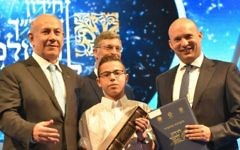 Prime Minister Benjamin Netanyahu, left, and Education Minister Naftali Bennett, right, with Sagiv Lugasi, winner of the annual International Bible Quiz at the Jerusalem Theater, May 2, 2017. (Shlomi Amsalem)