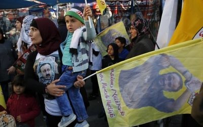 Palestinians hold flags bearing portraits of convicted Palestinian terrorist Marwan Barghouti during a rally in the West Bank city of Ramallah in support of prisoners on hunger strike on April 24, 2017. (AFP Photo/Abbas Momani)