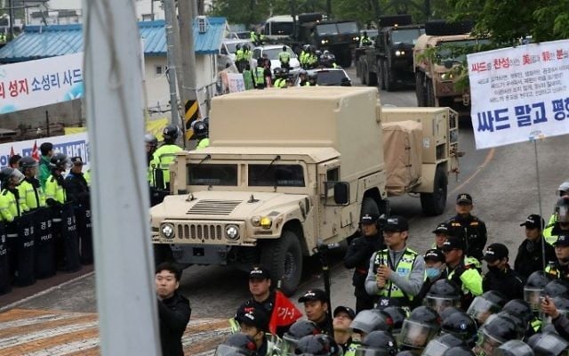 Protesters and police stand by as trailers carrying US THAAD missile defence equipment enter a deployment site in Seongju, South Korea, early on April 26, 2017. (AFP/Yonhap)