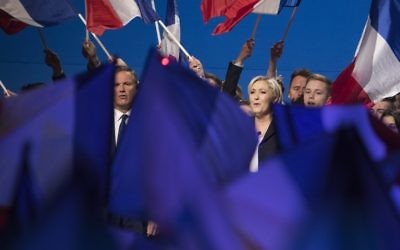 The French National Front's Marine Le Pen (R) and former French presidential election candidate for the right-wing Debout la France (DLF) party Nicolas Dupont-Aignan (L), sing the French National anthem at the end of a meeting at the Parc des Expositions in Villepinte, on May 1, 2017. (AFP/Joel Saget)