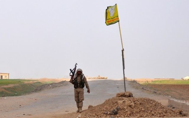 A fighter from the US-backed SDF walks next to the group's flag flying in the village of Kabsh Gharbi, on the northern outskirts of Raqqa, on May 2, 2017. (AFP Photo/Ayham al-Mohammad) A fighter from the US-backed SDF walks next to the group's flag flying in the village of Kabsh Gharbi, on the northern outskirts of Raqqa, on May 2, 2017. (AFP Photo/Ayham al-Mohammad)