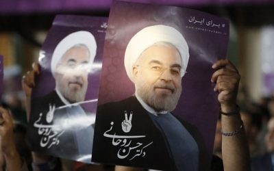 Supporters of Iranian President Hassan Rouhani hold his portrait during a campaign rally in the capital Tehran on May 4, 2017. (AFP Photo/Atta Kenare)