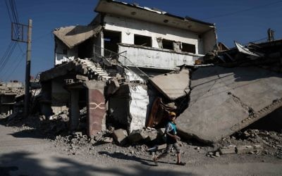 A Syrian boy walks past destroyed buildings in the rebel-held town of Douma, on the eastern outskirts of Damascus on May 6, 2017. (Sameer Al-Doumy/AFP)