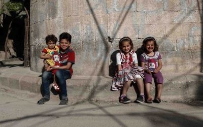 Syrian children pose for a photo near their house in the rebel-held town of Douma, on the eastern outskirts of Damascus on May 6, 2017. (Sameer Al-Doumy/AFP)