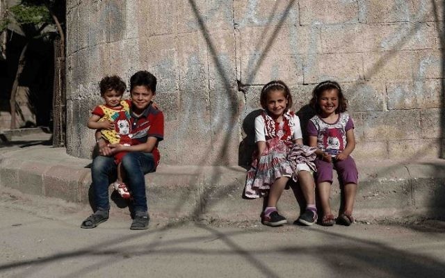 Syrian children pose for a photo near their house in the rebel-held town of Douma, on the eastern outskirts of Damascus on May 6, 2017. (Sameer Al-Doumy/AFP) Syrian children pose for a photo near their house in the rebel-held town of Douma, on the eastern outskirts of Damascus on May 6, 2017. (Sameer Al-Doumy/AFP)