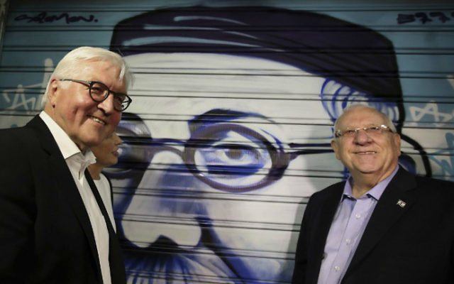 President Reuven Rivlin, right, and his German counterpart Frank-Walter Steinmeier, left, stand next to graffiti depicting Rivlin's great-grandfather as they visit the trendy outdoor Mahane Yehuda Market at night on May 6, 2017 in Jerusalem. (Gali Tibbon/AFP)