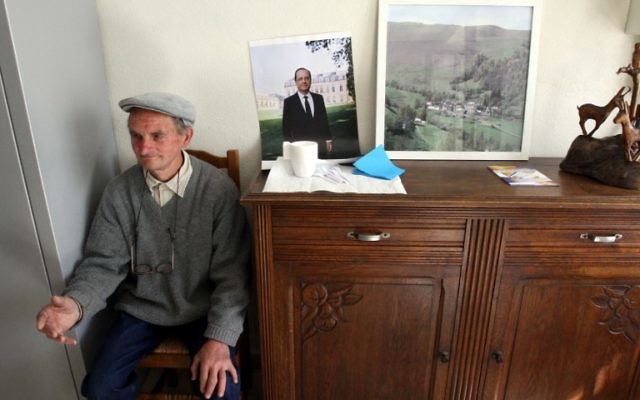A man sits next to a portrait of outgoing French President Francois Hollande in a polling station in Ourdon, in the French Pyrenees, May 7, 2017. (AFP/NR/LAURENT DARD) A man sits next to a portrait of outgoing French President Francois Hollande in a polling station in Ourdon, in the French Pyrenees, May 7, 2017. (AFP/NR/LAURENT DARD)