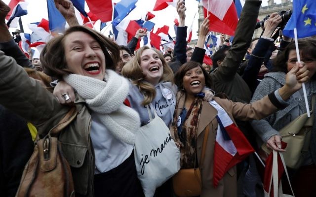 Following the announcement of the results of the second round of the French presidential election, supporters of French presidential election candidate for the En Marche movement Emmanuel Macron celebrate in front of the Pyramid at the Louvre Museum in Paris on May 7, 2017. (AFP/Patrick KOVARIK)