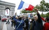 A man waves a French national flags next to people gesturing and shout on the French avenue of the Champs Elysees by the Arc de Triomphe on May 7, 2017, in Paris following the announcement of the results of the second round of the French presidential election. (AFP/ GEOFFROY VAN DER HASSELT)