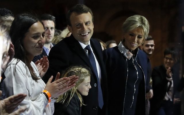 French president-elect Emmanuel Macron (C) and his wife Brigitte Trogneux (R) greet supporters in front of the Pyramid at the Louvre Museum in Paris on May 7, 2017, after the second round of the French presidential election. (AFP PHOTO / POOL / Thomas SAMSON) French president-elect Emmanuel Macron (C) and his wife Brigitte Trogneux (R) greet supporters in front of the Pyramid at the Louvre Museum in Paris on May 7, 2017, after the second round of the French presidential election. (AFP PHOTO / POOL / Thomas SAMSON)