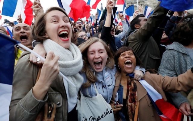 Supporters of French president-elect Emmanuel Macron react at the Louvre Museum in Paris on May 7, 2017, after the second round of the French presidential election. Emmanuel Macron was elected French president on May 7, 2017 in a resounding victory over far-right Front National (FN - National Front) rival after a deeply divisive campaign. / AFP PHOTO / Patrick KOVARIK