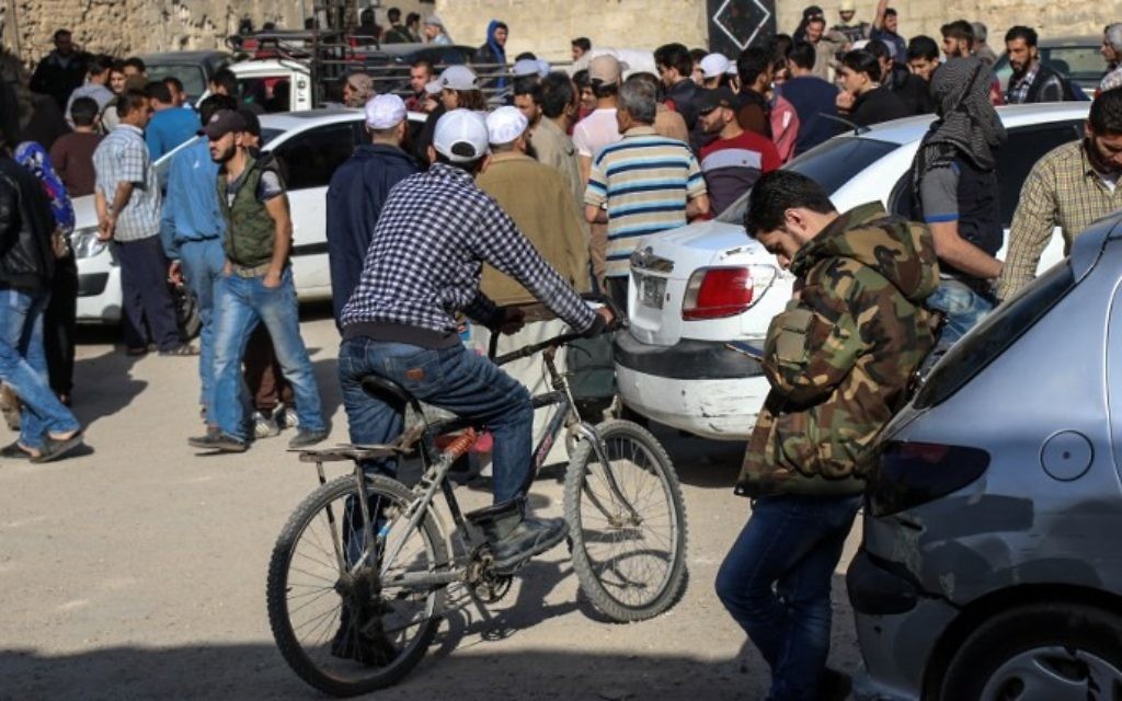 Syrian opposition fighters and their families gather at a staging point in the Barzeh neighborhood of the capital Damascus on May 8, 2017, as they wait to be evacuated. (AFP PHOTO / Saria ABU ZAID)