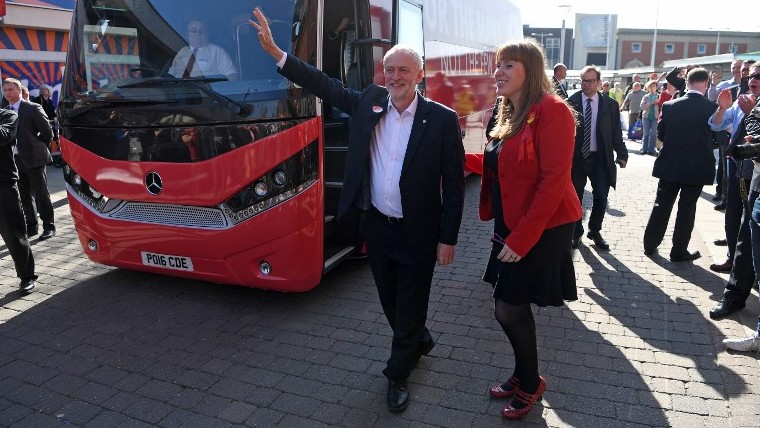 Britain's opposition Labour party Leader Jeremy Corbyn, center, waves to supporters as he is walks past a campaign bus in Ashton-under-Lyne, north-west England, May 9, 2017 (AFP/Paul ELLIS) Britain's opposition Labour party Leader Jeremy Corbyn, center, waves to supporters as he is walks past a campaign bus in Ashton-under-Lyne, north-west England, May 9, 2017 (AFP/Paul ELLIS)