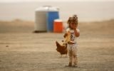 Illustrative image of a displaced child, who fled from the Islamic State (IS) group bastion of Raqqa, standing outside as she eats a loaf of bread in a camp for displaced near the town of al-Karamah on May 10, 2017. (AFP PHOTO / DELIL SOULEIMAN)