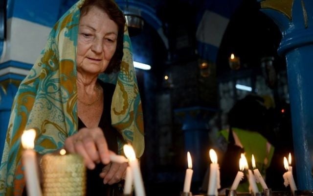 A Jewish woman lights a candle at the Ghriba synagogue in the Tunisian resort island of Djerba on May 12, 2017 during the first day of the annual Jewish pilgrimage to the synagogue on Tunisia's Mediterranean resort island of Djerba. (Fethi Belad/AFP)
