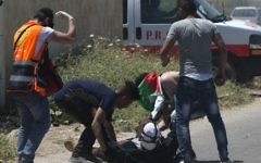 Palestinians tend to an injured demonstrator during clashes with Israeli forces in the West Bank village of Beit Furik, east of Nablus on May 12, 2017, after a demonstration following Friday prayers in solidarity with Palestinian prisoners on hunger strike in Israeli jails. (Jaafar Ashtiyeh/AFP)