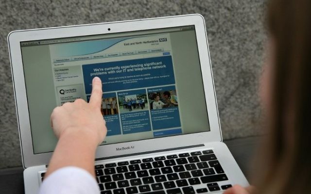 A woman points to the website of the NHS: East and North Hertfordshire notifying users of a problem in its network, in London on May 12, 2017. (AFP PHOTO / Daniel LEAL-OLIVAS) A woman points to the website of the NHS: East and North Hertfordshire notifying users of a problem in its network, in London on May 12, 2017. (AFP PHOTO / Daniel LEAL-OLIVAS)
