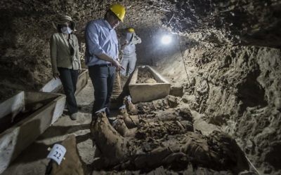 Illustrative: Egyptian Antiquities Minister Khaled el-Enany (C) speaks to the media on May 13, 2017, in front of mummies following their discovery in catacombs in the Tuna el-Gabal district of the Minya province, in central Egypt. (AFP Photo/Khaled Desouki)