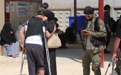 Syrians embrace as civilians and rebels, who were evacuated from the Qabun district in northeast Damascus, arrive at a temporary camp in the northern countryside of Idlib province on May 15, 2017. (Ibrahim Yasouf/AFP)