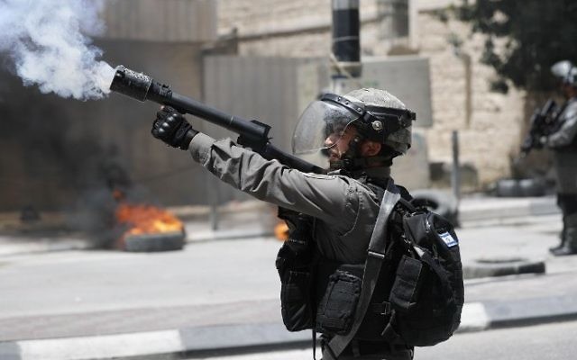 A Border Police officer fires tear gas during 'Nakba' Day clashes with Palestinians in the West Bank city of Bethlehem, on May 15, 2017. (AFP Photo/Thomas Coex) A Border Police officer fires tear gas during 'Nakba' Day clashes with Palestinians in the West Bank city of Bethlehem, on May 15, 2017. (AFP Photo/Thomas Coex)