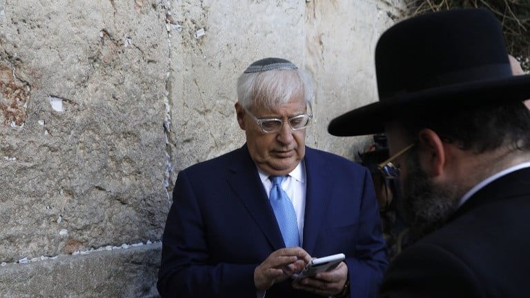 New US ambassador to Israel David Friedman stands next to Rabbi Shmuel Rabinovitch (R) while praying at the Western Wall in the Old City of Jerusalem on May 15, 2017. (AFP Photo/Menahem Kahana) New US ambassador to Israel David Friedman stands next to Rabbi Shmuel Rabinovitch (R) while praying at the Western Wall in the Old City of Jerusalem on May 15, 2017. (AFP Photo/Menahem Kahana)
