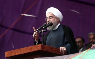 Iranian President Hassan Rouhani gives an address at a campaign rally in the northeastern city of Mashhad on May 17, 2017. (AFP Photo/Behrouz Mehri)