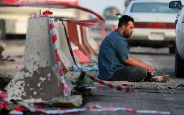 An Iraqi man sits on the tarmac at the site of a car bomb attack, in the southern Iraqi city of Basra on May 20, 2017. ( AFP PHOTO / HAIDAR MOHAMMED ALI) An Iraqi man sits on the tarmac at the site of a car bomb attack, in the southern Iraqi city of Basra on May 20, 2017. ( AFP PHOTO / HAIDAR MOHAMMED ALI)