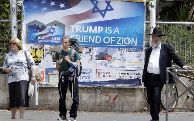 Israelis walks past a poster welcoming and supporting US President Donald Trump in downtown Jerusalem, on May 21, 2017, on the eve of a two-day visit of the US president. (AFP/ MENAHEM KAHANA)