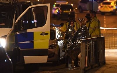 Concert goers wait to be picked up at the scene of a terror attack during a pop concert by US star Ariana Grande in Manchester, northwest England on May 23, 2017. (AFP/Paul Ellis) Concert goers wait to be picked up at the scene of a terror attack during a pop concert by US star Ariana Grande in Manchester, northwest England on May 23, 2017. (AFP/Paul Ellis)