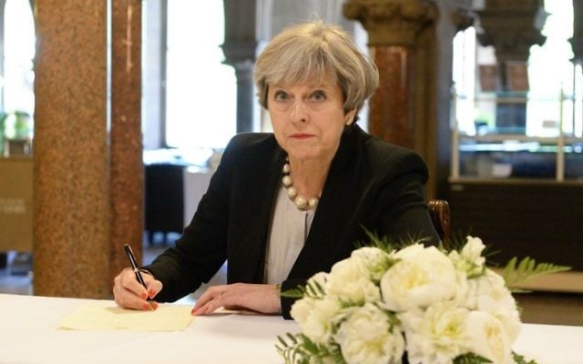 Britain's Prime Minister Theresa May writes a message in a book of condolence at Manchester Town Hall on May 23, 2017, following the terror attack at the Ariana Grande concert at the Manchester Arena on May 22. (Ben Birchall/Pool/AFP) Britain's Prime Minister Theresa May writes a message in a book of condolence at Manchester Town Hall on May 23, 2017, following the terror attack at the Ariana Grande concert at the Manchester Arena on May 22. (Ben Birchall/Pool/AFP)
