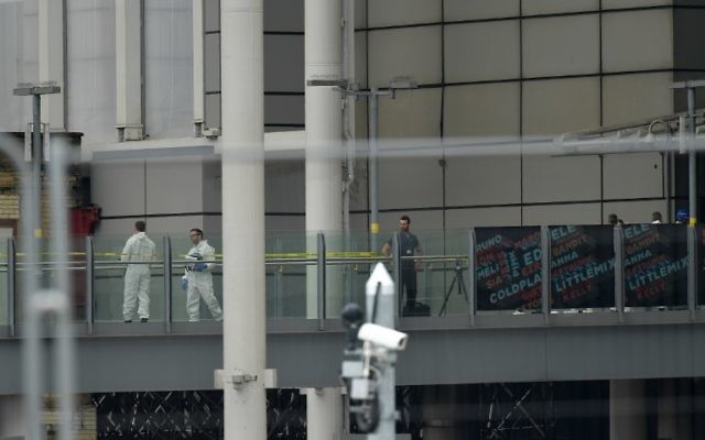 Police forensics officers work outside the entrance of the Manchester Arena box office, close to Victoria Station in Manchester, northwest England on May 24, 2017, following the May 22 terror attack at the Manchester Arena. AFP/ Ben STANSALL)