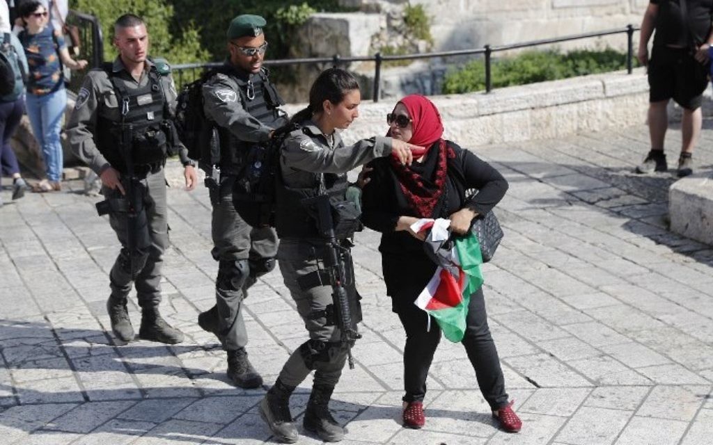 Border Police officers clear a woman with a Palestinian flag from outside Damascus Gate in Jerusalem's Old City on May 24, 2017, ahead of the annual Jerusalem Day march.  (AFP Photo/Thomas Coex)