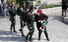 Border Police officers clear a woman with a Palestinian flag from outside Damascus Gate in Jerusalem's Old City on May 24, 2017, ahead of the annual Jerusalem Day march.  (AFP Photo/Thomas Coex)