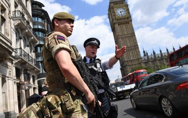 A British Army soldier patrols with an armed police officer near the Houses of Parliament in central London on May 24, 2017. AFP/ Justin TALLIS)